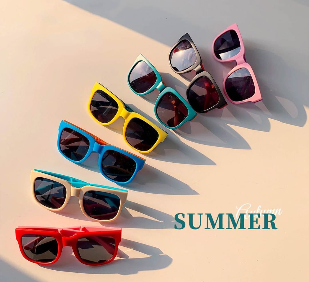 Colorful sunglasses on a light surface with 'Summer' text