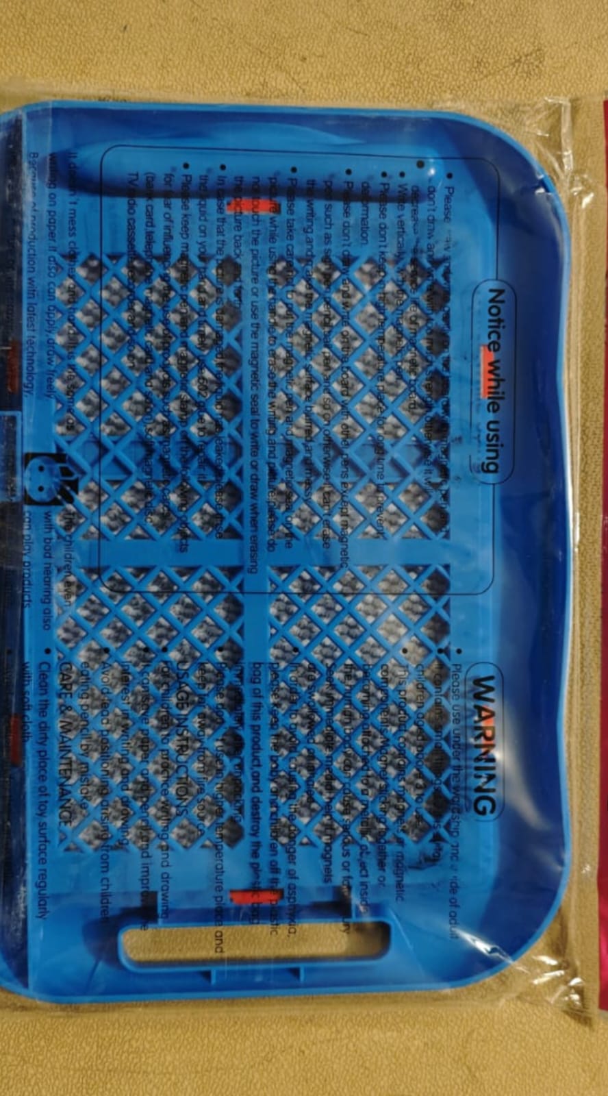 Blue plastic tray with multiple holes on a beige background