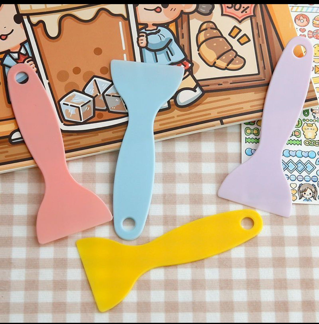 Colorful spatulas on a checkered tablecloth with cartoon illustrations in the background