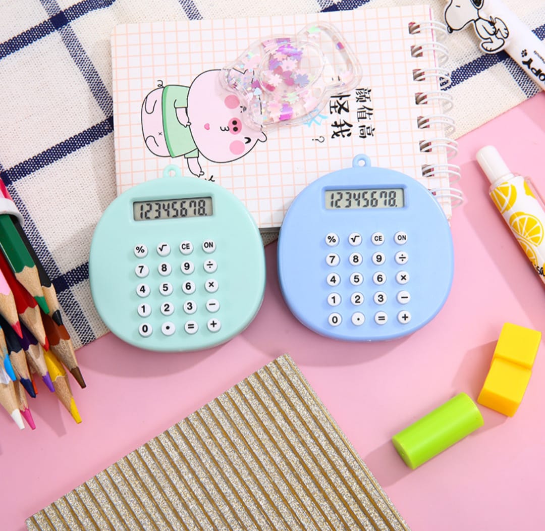Two small calculators on a desk with stationery items