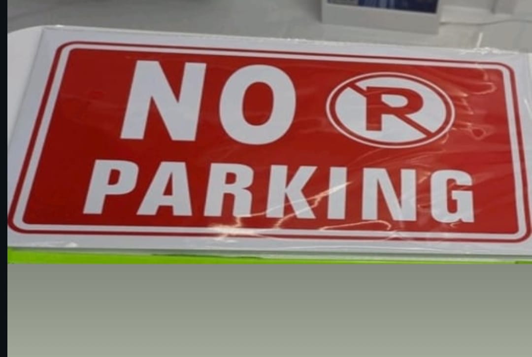 No parking sign with a red background and white text.