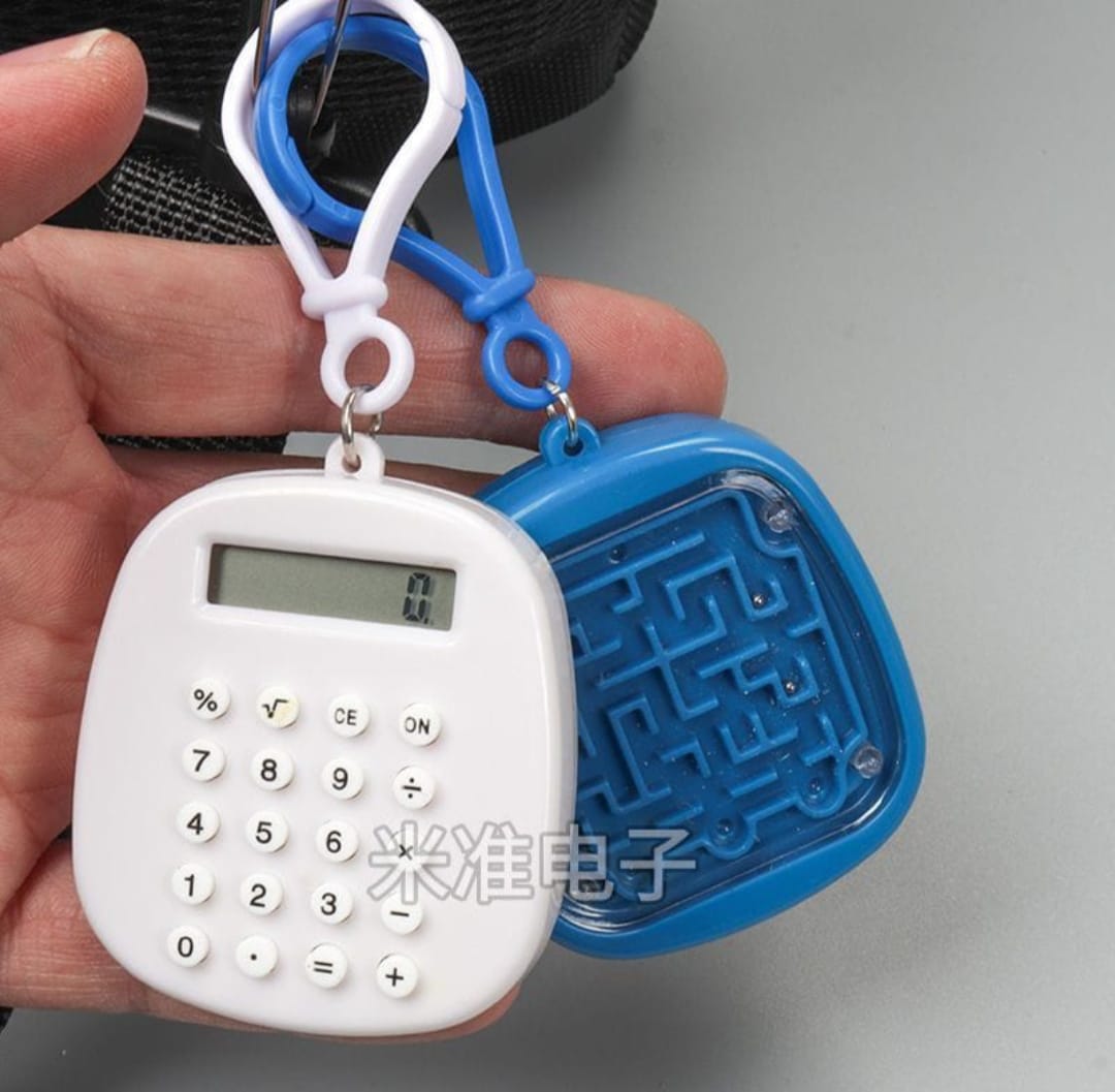 Small calculator with maze design on a keychain, held by a hand.