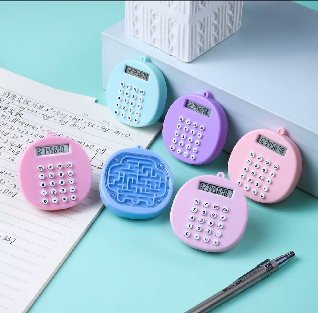 Set of colorful calculators on a light blue surface with a pen and paper.