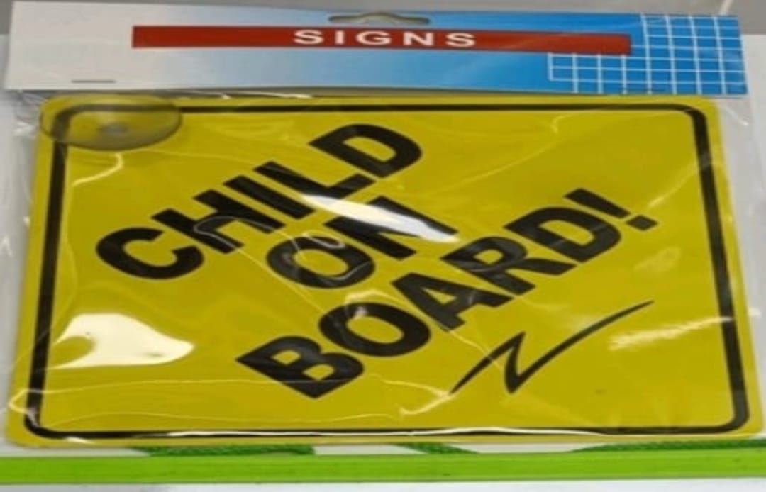 Yellow 'Child on Board!' sign with black text, in packaging.