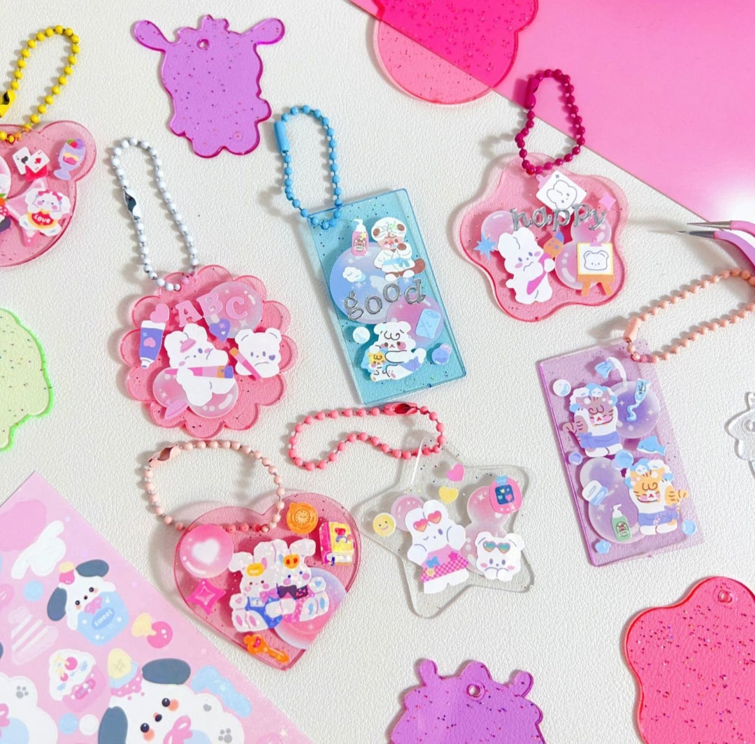 Collection of colorful keychains and charms on a pink background
