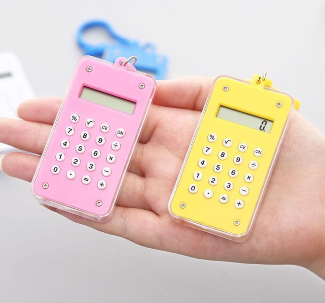 Pink and yellow calculators held in a hand against a light background