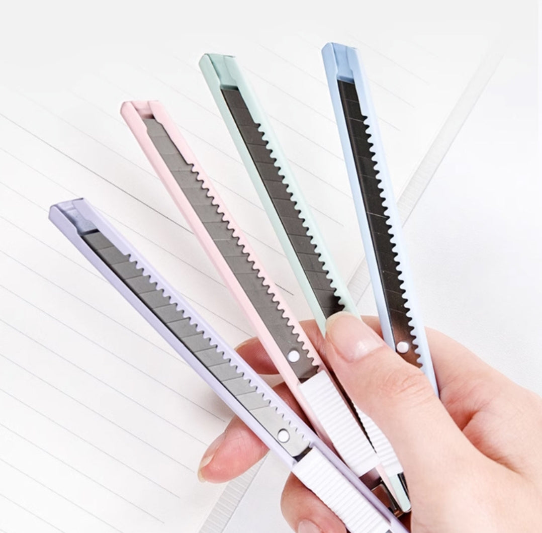 Set of four small razors held by a hand with a white background