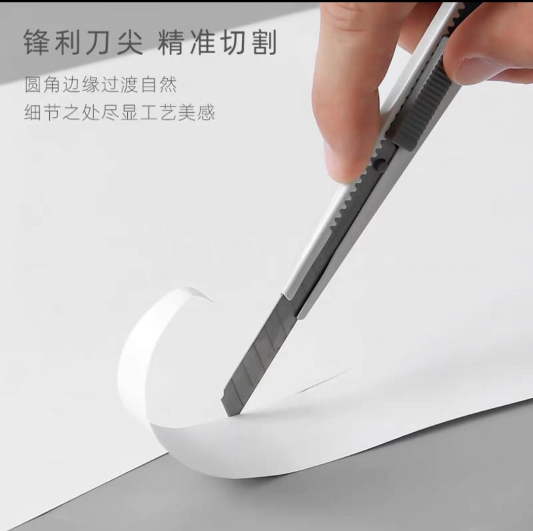 Person using a paper cutter on white paper with text in the background