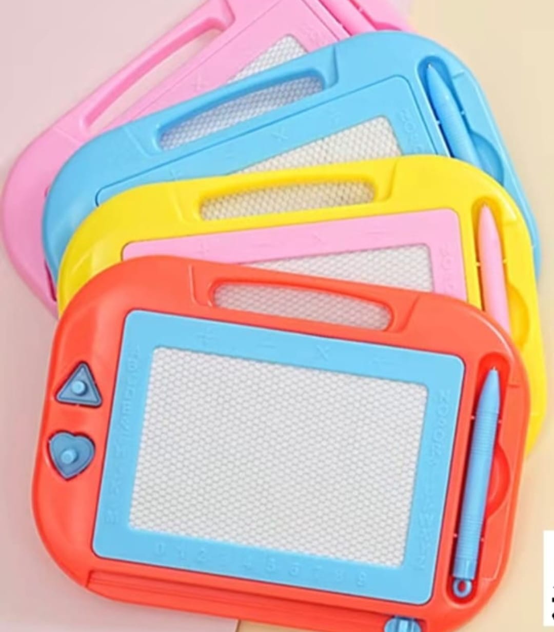 Colorful children's drawing boards with pens on a pink background