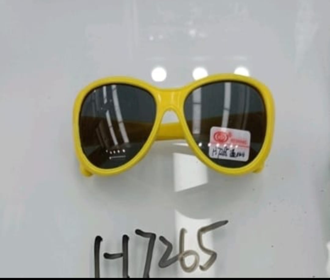 Yellow sunglasses on a white stand with a visible brand label.